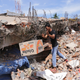 A man removes a box of food from under the rubble of a building that collapsed after the earthquake. (Image: AP/Heri Juanda)